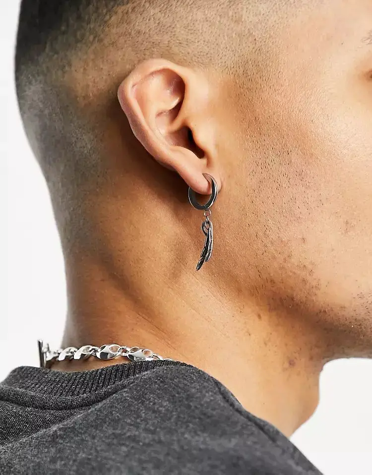 ASOS DESIGN 10mm stainless steel hoop earrings with feather charms in burnished silver tone