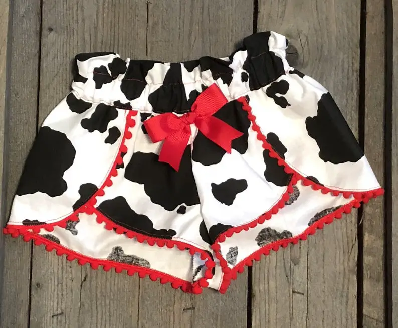 Black and White Cow Print Shorts with Red Pom Poms
